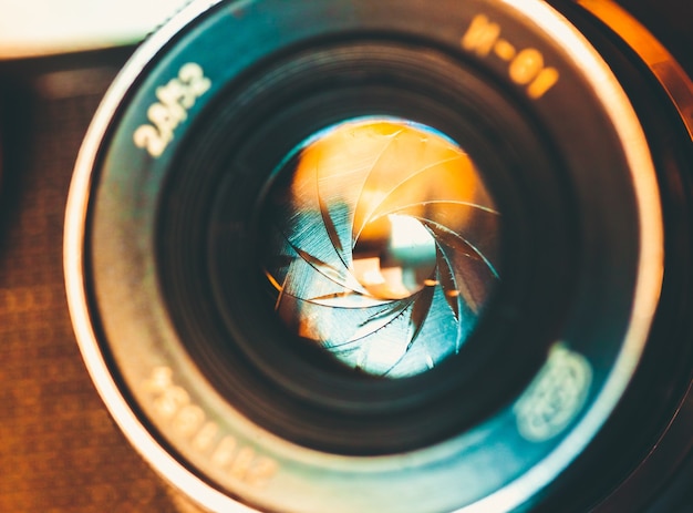 Cameralens met lensreflecties op de achtergrond.