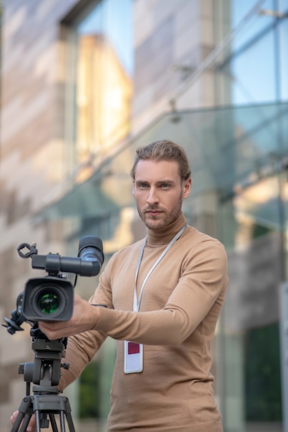 Foto cameraman che installa la macchina fotografica sul treppiede