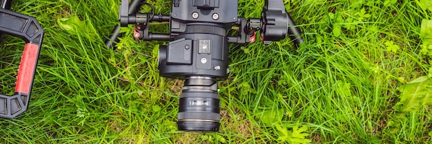 Foto cameraman zet zware professionele as-gimbal-stabilisator op voor bioscoopcamerabanner lang