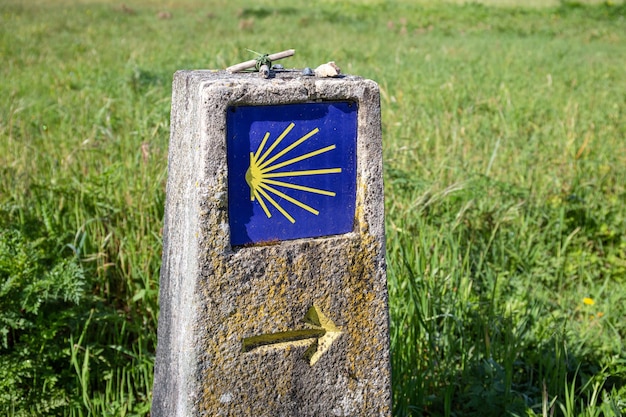Camino de Santiago sign. Pilgrimage to Santiago de Compostela concept. Way of Saint James shell sign and yellow arrow