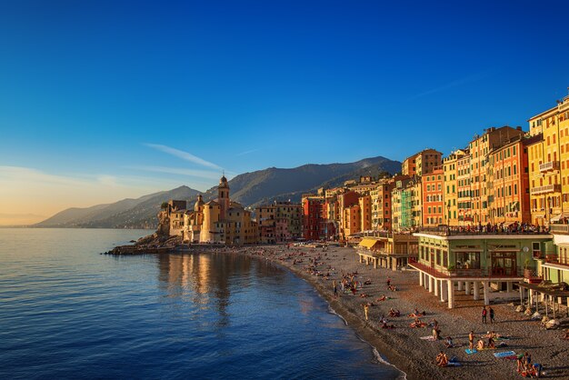 Camogli, Italy - 07 November 2015. Scenic Mediterranean riviera coast. View of Camogli town in Liguria, Italy. Basilica of Santa Maria Assunta and colorful palaces, beach with people.