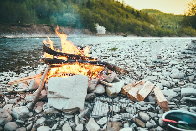 Camp fire on riverside in carpathian mountains