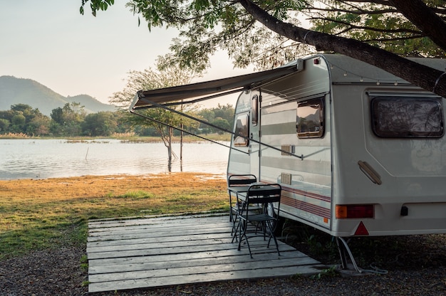 Camper geparkeerd in de buurt van het meer op de camping 's avonds op vakantie