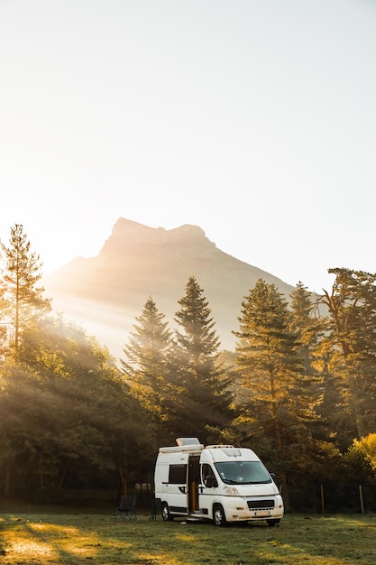 Camper in een vallei met een prachtig uitzicht op het landschap van bosbergen en zonnestralen tijdens zonsopgang