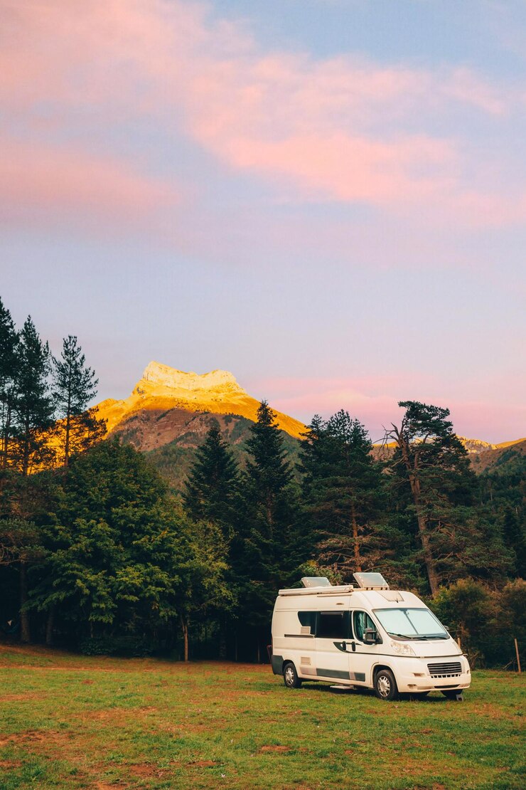 Photo camper van with amazing landscape views of forest and mountains during sunset van road trip holiday