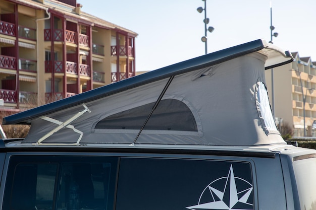 Фото Кемпер-фургон с открытым палаточным лагерем на крыше на побережье для отдыха на пляже