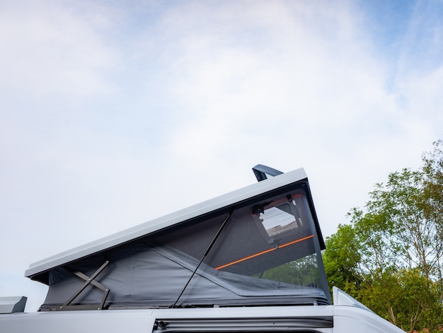 Camper van with tent on roof on dealership showroom