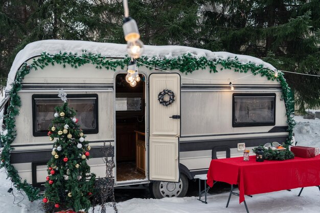 Foto campervan motorhome in campeggio invernale decorato per natale o felice festa di capodanno