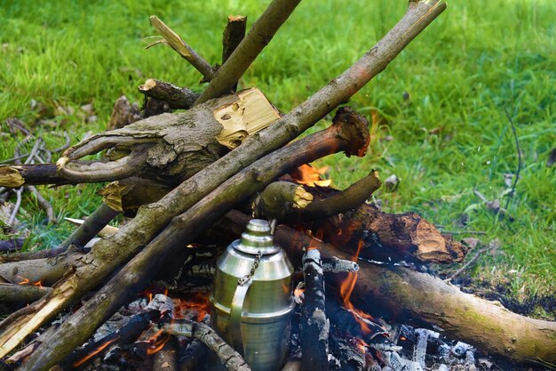 A campfire with a metal pot on it