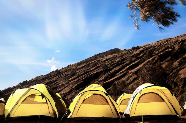 산속의 캠핑장 푸른 하늘을 배경으로 많은 노란색 텐트
