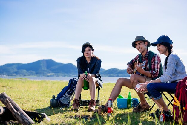 写真 自然の幸せな友達のパーティーでキャンプをし、夏の自然の森で一緒にギターを弾く