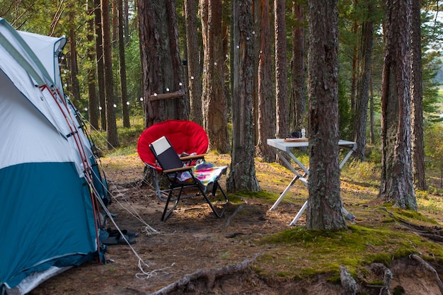 camping a folding tent in the camp a collapsible table and an armchair camping