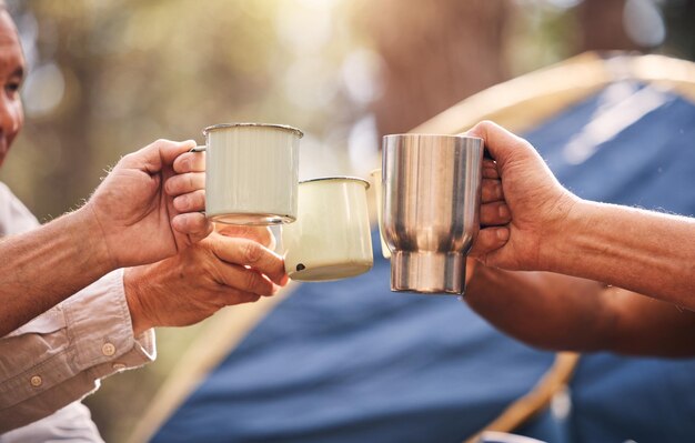 Photo camping hands mugs and people toast on outdoor nature vacation for wellness freedom or natural forest peace drinks group cheers and relax friends celebrate on holiday adventure in australia woods