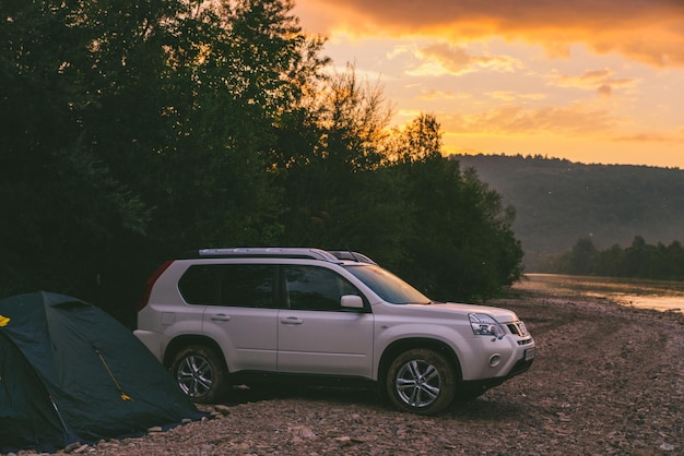 camping at rivershore on sunrise white suv car