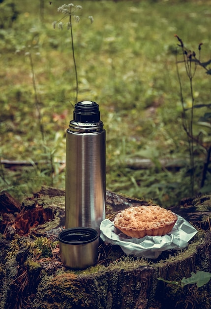 Camping thermos di tè nella foresta