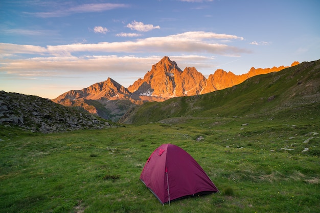 Campeggio con tenda sulle alpi. cielo scenico al tramonto. avventura che conquista le avversità.