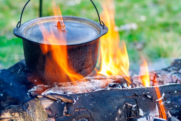 Campingkeukengerei - pot op het vuur op een openluchtcamping