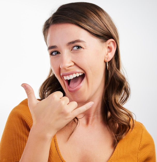 Can I give you a call sometime Studio shot of a young woman making a phone sign with her hand against a background