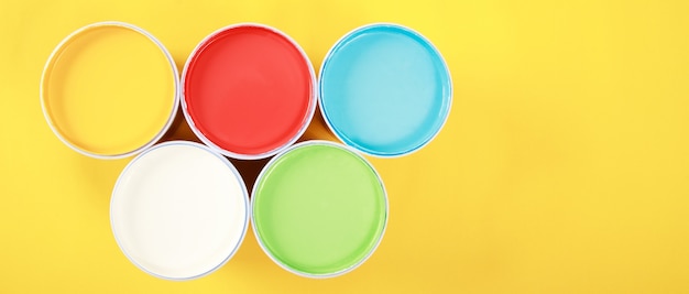 Photo a can of interior wall paint is placed on a yellow background.