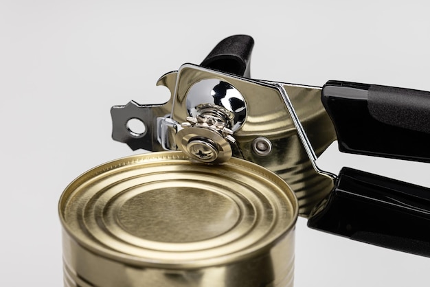 A can opener opening a can of food Kitchen utensils closeup