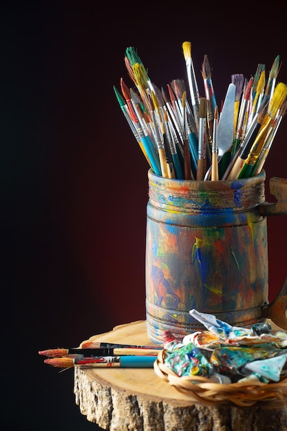 A can of paint and brushes sits on a table.