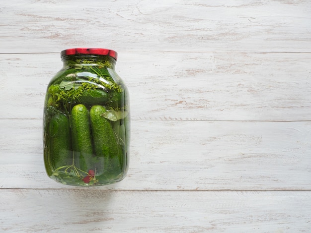 Can of pickles for the winter on a white wooden background