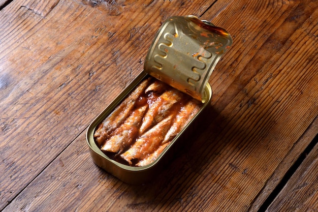 Lattina di sardine con salsa di pomodoro su fondo in legno