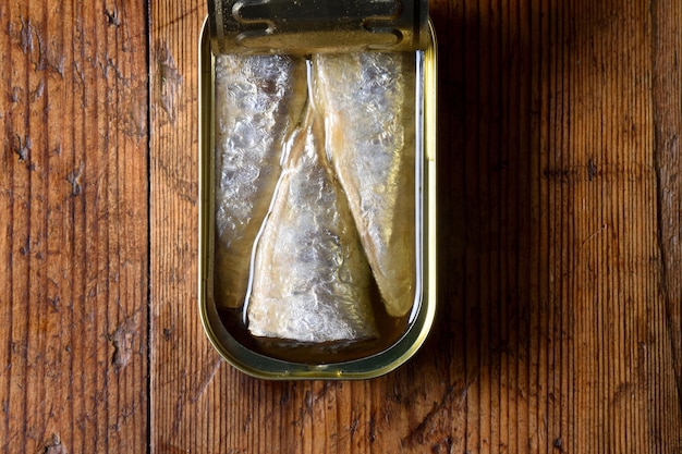 Lattina di sardine su fondo in legno