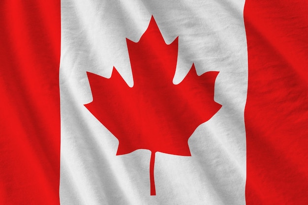 Canada flag with big folds waving close up under the studio light indoors The official symbols and colors in banner