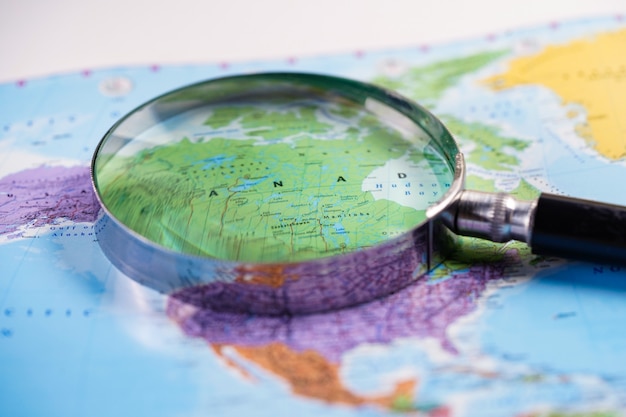 Photo canada : magnifying glass with world glove map.