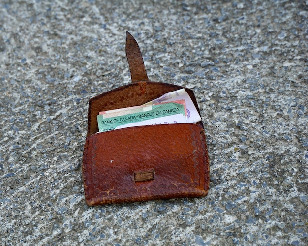 Photo canadian dollars banknote in a vintage leather wallet on concrete backgroundmoney concept