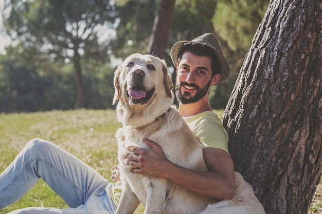 canadian labrador dog resting in the park with his owner on a sunny day