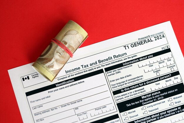 Photo canadian t general tax form income tax and benefit return lies on table with canadian money bills