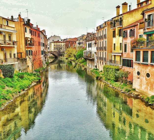 Foto canale in mezzo alle case contro il cielo in città