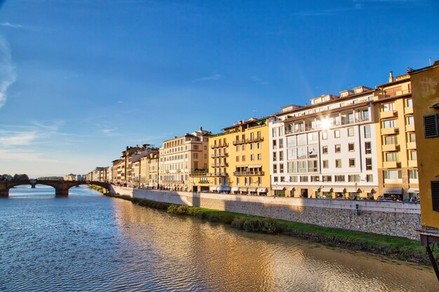 Canal by buildings in city against sky