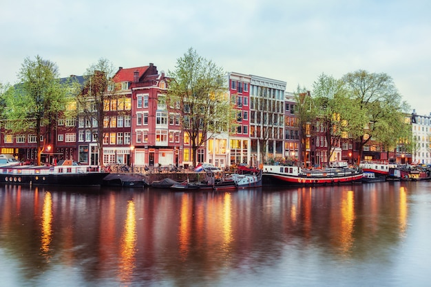 Canal houses of Amsterdam at dusk with vibrant reflections