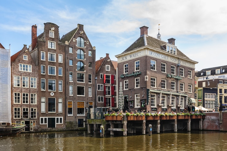 Photo canal houses of damrak, amsterdam, netherlands