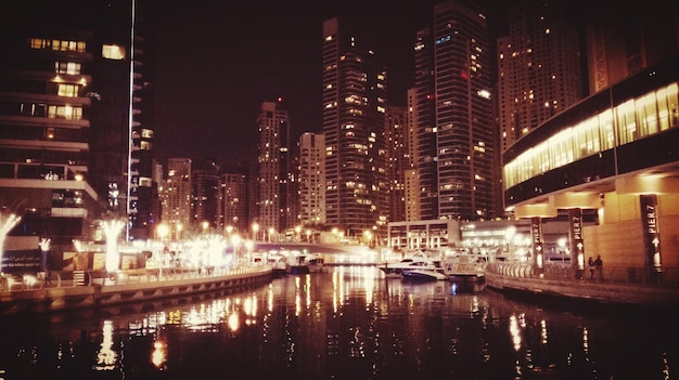 Photo canal in illuminated modern city at night