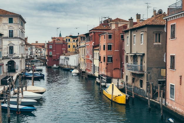 ボートとイタリアのヴェネツィアの近くのキオッジャのカラフルな家の運河