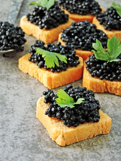 Canapé met zwarte kaviaar en greens.