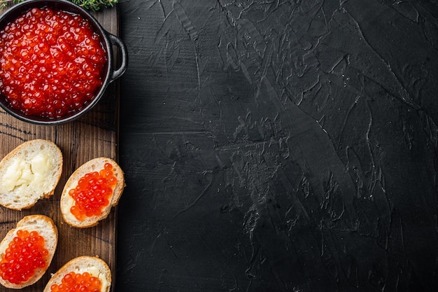 Canape with Red Salmon Caviar for New Year on black background top view flat lay with copy space for text