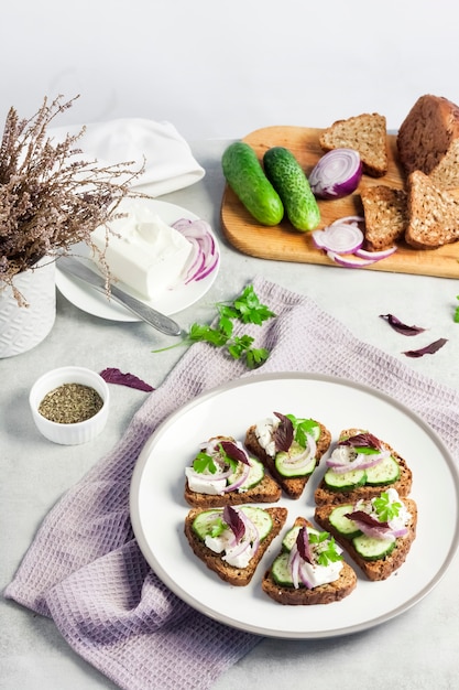 Canapeetjes met geroosterd brood met zonnebloem- en lijnzaad feta kaas komkommer en ui