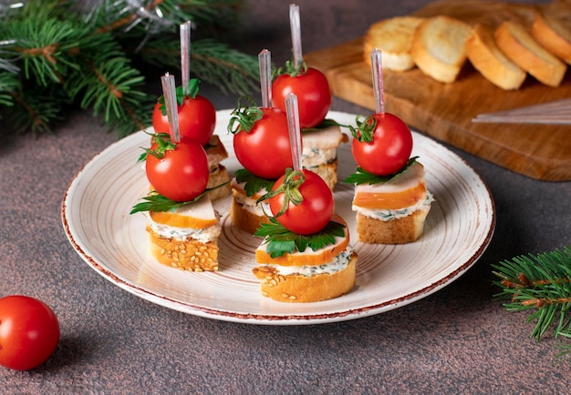 Photo canapes with croutons smoked chicken cheese and cherry tomatoes on brown background