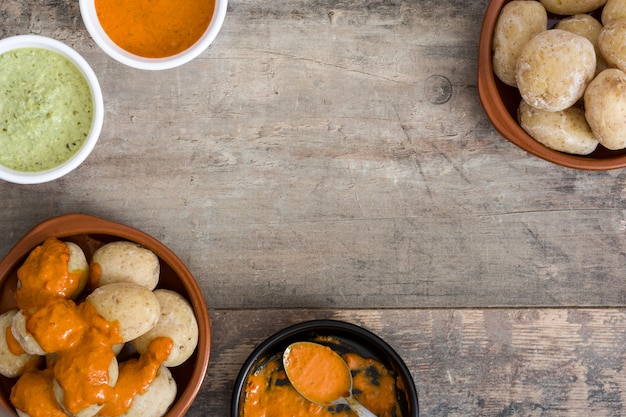 Canarian potatoes with mojo sauce on wooden table. 