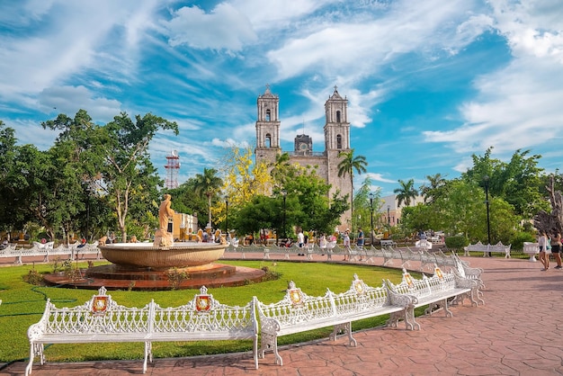 Cancún, Mexico. 30 mei 2021. Voetpad te midden van tuin en fontein met kerk San Servacio in Valladolild