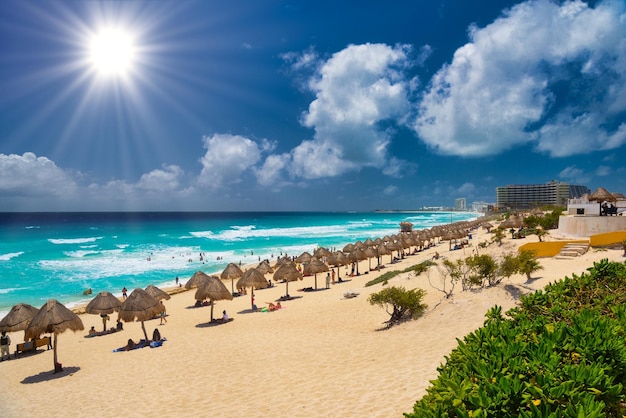 CANCUN MEXICO APR 2022 Зонтики на песчаном пляже с лазурной водой в солнечный день недалеко от Канкуна в Мексике