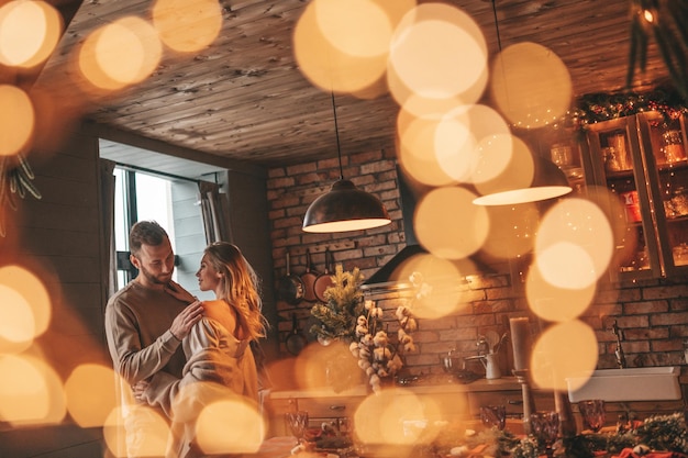 Candid authentic happy married couple spending time together at wooden lodge Xmas decorated