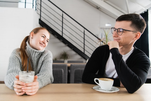 Foto immagine schietta di giovani coppie che sorridono in una caffetteria