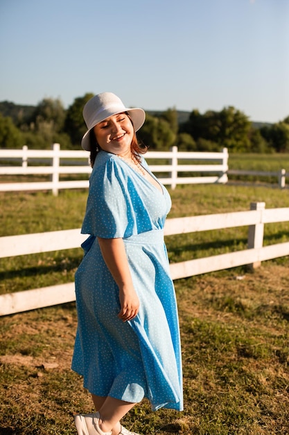 La candida donna con il cappello a terreni agricoli si gode l'estate