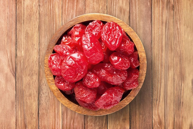 Candied fruit dried dogwood with sugar in bowl on wooden table background top view organic vegetarian food